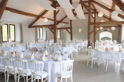 Vue aérienne d'un complexe avec plusieurs bâtiments, un jardin central, un parking et des zones identifiées par des noms.