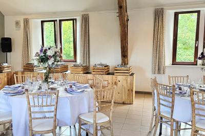 Vue aérienne d'un complexe avec plusieurs bâtiments, un jardin central, un parking et des zones identifiées par des noms.