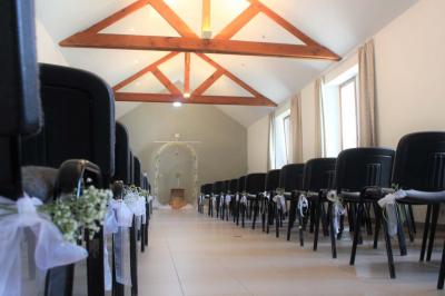 Vue aérienne d'un complexe avec plusieurs bâtiments, un jardin central, un parking et des zones identifiées par des noms.