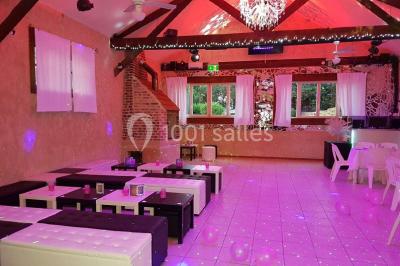 Pièce montée en forme d'anneaux entrelacés avec des figurines de mariés, entourée de bouteilles de champagne.