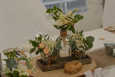 Pièce montée en forme d'anneaux entrelacés avec des figurines de mariés, entourée de bouteilles de champagne.