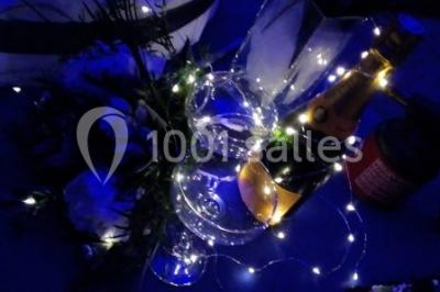 Pièce montée en forme d'anneaux entrelacés avec des figurines de mariés, entourée de bouteilles de champagne.