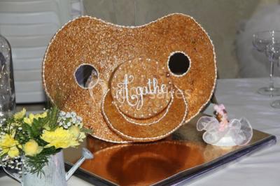 Pièce montée en forme d'anneaux entrelacés avec des figurines de mariés, entourée de bouteilles de champagne.