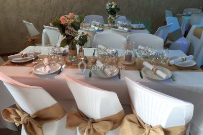 Pièce montée en forme d'anneaux entrelacés avec des figurines de mariés, entourée de bouteilles de champagne.