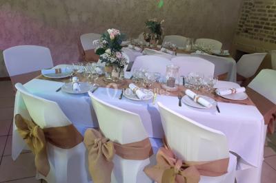 Pièce montée en forme d'anneaux entrelacés avec des figurines de mariés, entourée de bouteilles de champagne.