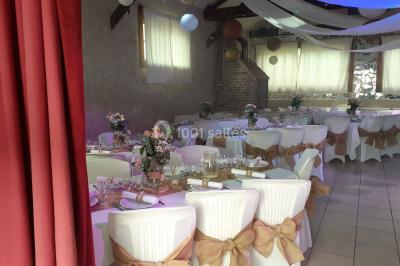 Pièce montée en forme d'anneaux entrelacés avec des figurines de mariés, entourée de bouteilles de champagne.