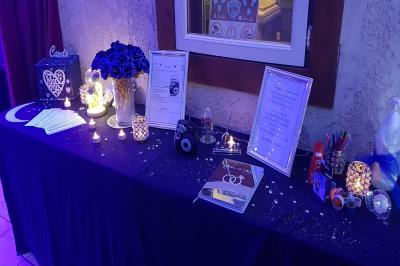 Pièce montée en forme d'anneaux entrelacés avec des figurines de mariés, entourée de bouteilles de champagne.