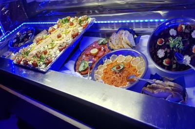 Pièce montée en forme d'anneaux entrelacés avec des figurines de mariés, entourée de bouteilles de champagne.