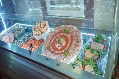 Pièce montée en forme d'anneaux entrelacés avec des figurines de mariés, entourée de bouteilles de champagne.