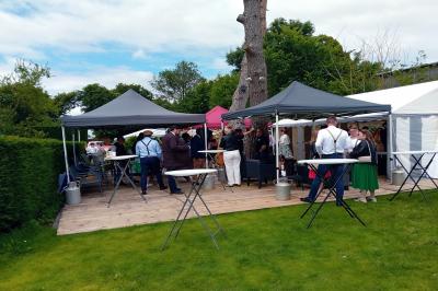 Pièce montée en forme d'anneaux entrelacés avec des figurines de mariés, entourée de bouteilles de champagne.