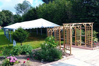 Pièce montée en forme d'anneaux entrelacés avec des figurines de mariés, entourée de bouteilles de champagne.