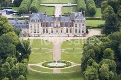 Peinture de mains et flèche blanche sur un tronc d'arbre dans un parc enneigé, avec des arbres en arrière-plan.