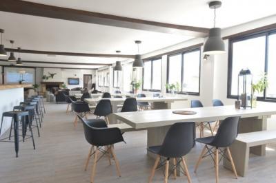 Quatre femmes pratiquant le yoga en posture de l'arbre sur des tapis colorés dans un espace extérieur herbeux.