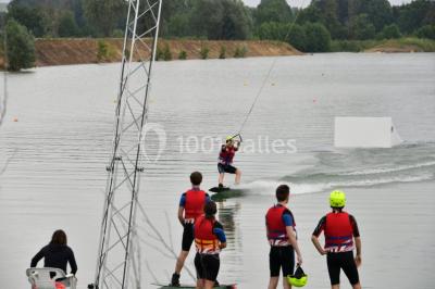 Des personnes en gilets de sauvetage et casques jaunes font du bouée tractée sur un plan d'eau.