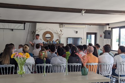 Des personnes en gilets de sauvetage et casques jaunes font du bouée tractée sur un plan d'eau.