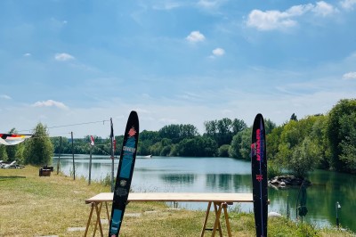 Des personnes en gilets de sauvetage et casques jaunes font du bouée tractée sur un plan d'eau.
