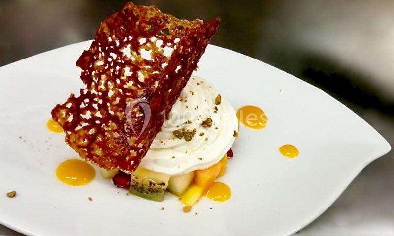 Dessert composé de fruits frais, crème fouettée, coulis de mangue et tuile croustillante en décoration.