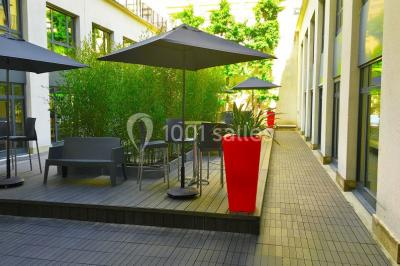 Salle de conférence moderne avec rangées de sièges en bois et éclairage suspendu.