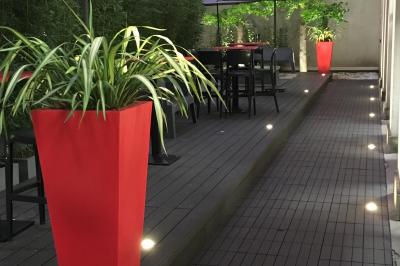 Salle de conférence moderne avec rangées de sièges en bois et éclairage suspendu.