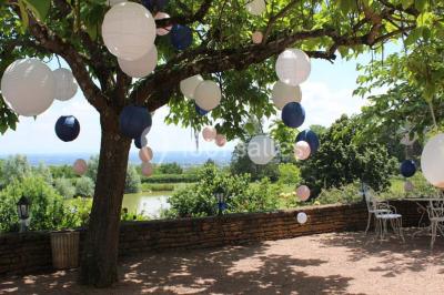 Vue aérienne d'un village avec un étang, des champs, des arbres et des collines à l'horizon.