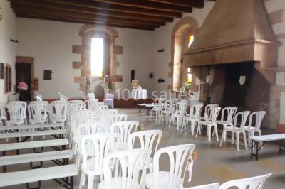 Vue aérienne d'un village avec un étang, des champs, des arbres et des collines à l'horizon.