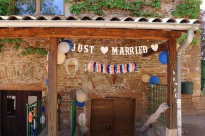 Vue aérienne d'un village avec un étang, des champs, des arbres et des collines à l'horizon.