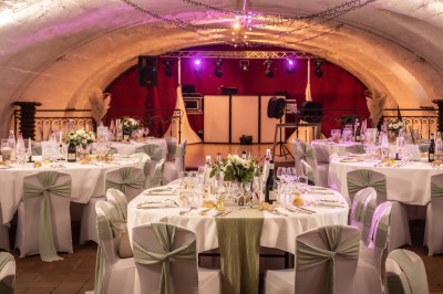 Chambre lumineuse avec lit double, poutres apparentes, parquet en bois, miroir doré et bureau ancien.