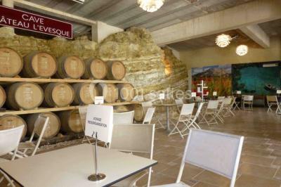 Bouteilles de vin blanc ’Hauts de L'Évêque 2018’ exposées sur un présentoir en bois dans une cave à vin.
