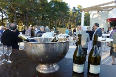 Bouteilles de vin blanc ’Hauts de L'Évêque 2018’ exposées sur un présentoir en bois dans une cave à vin.