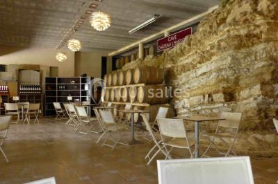 Bouteilles de vin blanc ’Hauts de L'Évêque 2018’ exposées sur un présentoir en bois dans une cave à vin.