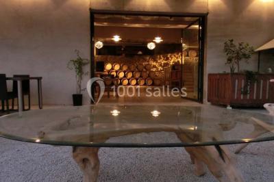 Bouteilles de vin blanc ’Hauts de L'Évêque 2018’ exposées sur un présentoir en bois dans une cave à vin.