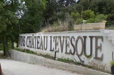 Bouteilles de vin blanc ’Hauts de L'Évêque 2018’ exposées sur un présentoir en bois dans une cave à vin.