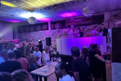 Bouteilles de vin blanc ’Hauts de L'Évêque 2018’ exposées sur un présentoir en bois dans une cave à vin.