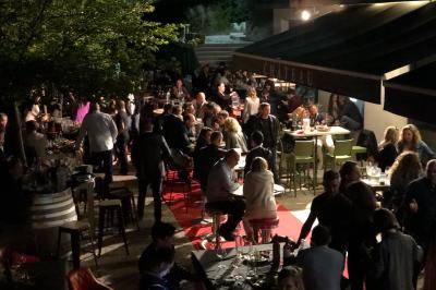 Bouteilles de vin blanc ’Hauts de L'Évêque 2018’ exposées sur un présentoir en bois dans une cave à vin.