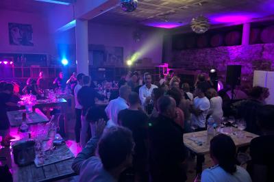 Bouteilles de vin blanc ’Hauts de L'Évêque 2018’ exposées sur un présentoir en bois dans une cave à vin.