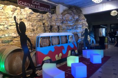 Bouteilles de vin blanc ’Hauts de L'Évêque 2018’ exposées sur un présentoir en bois dans une cave à vin.