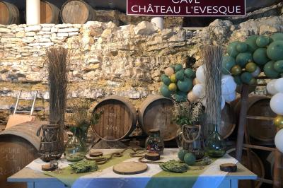 Bouteilles de vin blanc ’Hauts de L'Évêque 2018’ exposées sur un présentoir en bois dans une cave à vin.