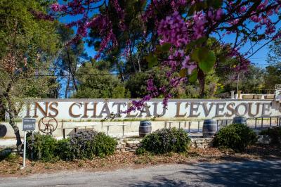Bouteilles de vin blanc ’Hauts de L'Évêque 2018’ exposées sur un présentoir en bois dans une cave à vin.