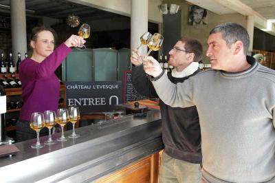 Bouteilles de vin blanc ’Hauts de L'Évêque 2018’ exposées sur un présentoir en bois dans une cave à vin.