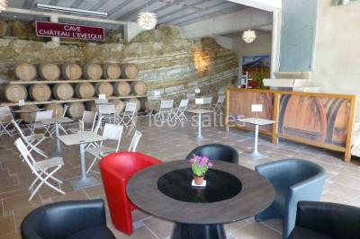 Groupe de personnes discutant sur une terrasse extérieure, entourée de fleurs et de mobilier de jardin.