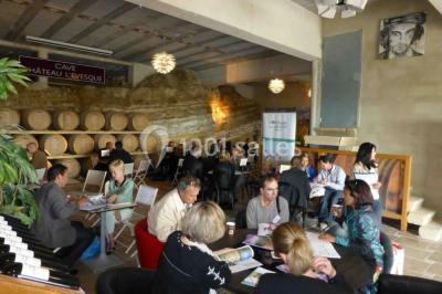 Groupe de personnes discutant sur une terrasse extérieure, entourée de fleurs et de mobilier de jardin.