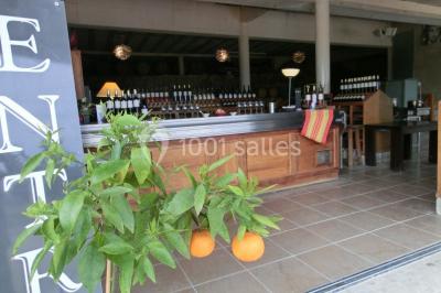 Groupe de personnes discutant sur une terrasse extérieure, entourée de fleurs et de mobilier de jardin.