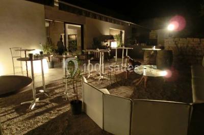 Groupe de personnes discutant sur une terrasse extérieure, entourée de fleurs et de mobilier de jardin.