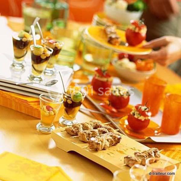 Table garnie de verrines, tomates farcies et amuse-bouches variés, présentés pour un buffet ou un apéritif.