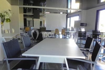 Groupe de personnes discutant sur une terrasse extérieure, entourée de fleurs et de mobilier de jardin.