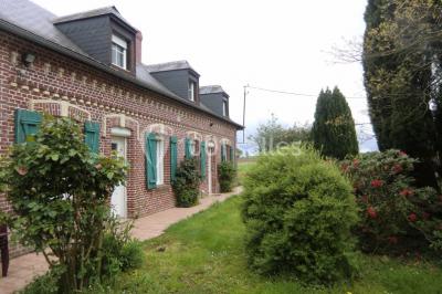 Table élégamment dressée avec nappes blanches, bougies, fleurs, verres et petits pains alignés.
