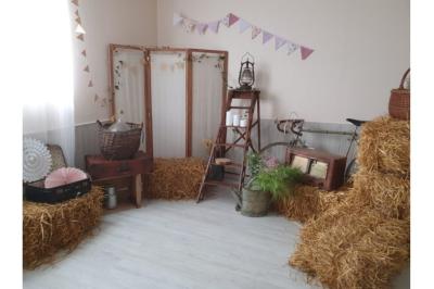 Table élégamment dressée avec nappes blanches, bougies, fleurs, verres et petits pains alignés.