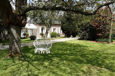 Table élégamment dressée avec nappes blanches, bougies, fleurs, verres et petits pains alignés.