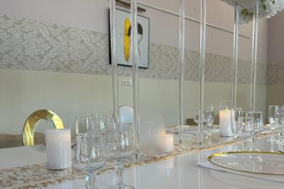 Piscine extérieure entourée de tables hautes, chaises colorées et structures gonflables, avec colline en arrière-plan.