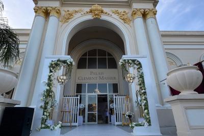 Piscine extérieure entourée de tables hautes, chaises colorées et structures gonflables, avec colline en arrière-plan.